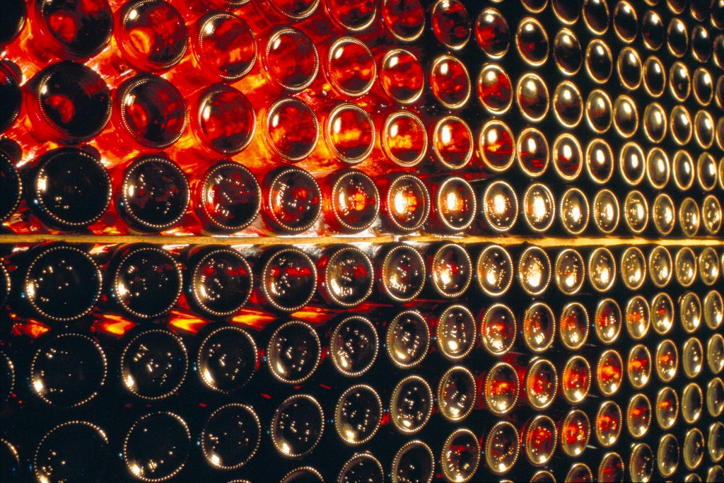 Wein im Keller: Zahlreiche Weinflaschen liegend gelagert