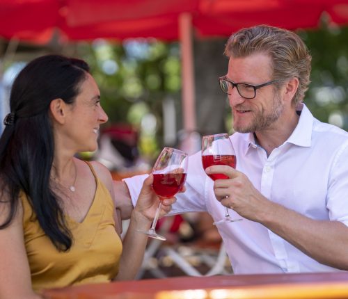 Ein Paar sitzt im Weinpavillon an der Neckarbühne und genießt ein Glas Wein