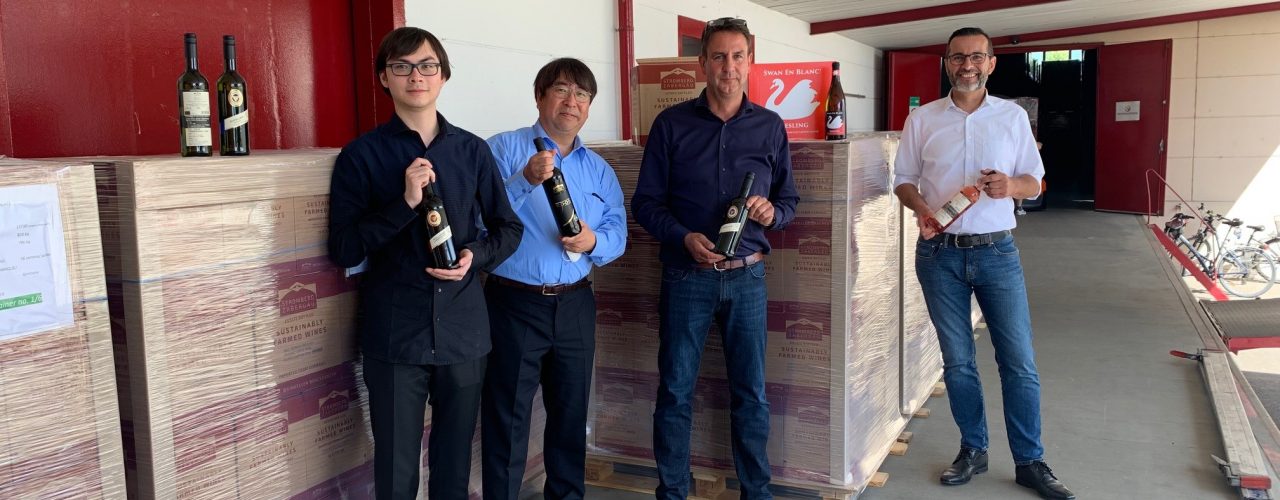 Ryo Shiga, Tomo Shiga, Bernd Kost und Jürgen Conz vor den versandfertigen Paletten der Weingärtner Stromberg-Zabergäu
