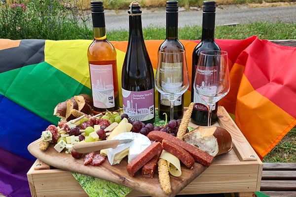 Vesperbrett und die vier Weine der Fellbacher Weingärtner, mit denen der CSD 2021 in Stuttgart unterstützt werden soll, vor einer Regenbogenflagge