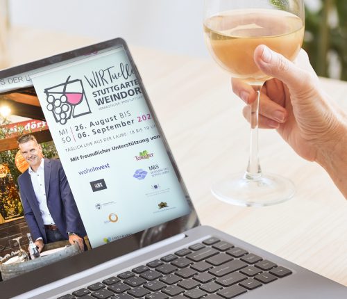 Frau sitzt mit einem Glas Wein vor dem Computer und schaut sich das Stuttgarter Weindorf online an