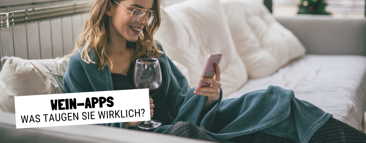 Frau sitzt auf Sofa mit Wein der Weinheimat Württemberger in der Hand auf dem Handy nach Wein Apps