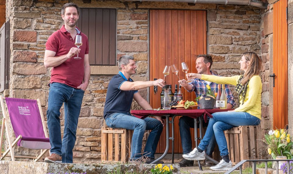 Events im Juli 2022: Das Weinfest der Genossenschaftskellerei Heilbronn, man sieht auf dem Bild mehrere Mitarbeiter und eine Mitarbeiterin der Genossenschaft, die mit Wein anstoßen.