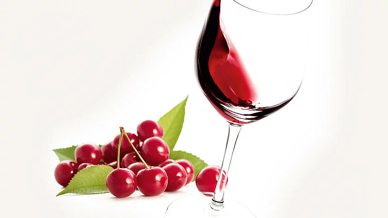 Grafik zum Trollinger: Rotweinglas mit Kirschen, dem typischen Aroma dieses Weines