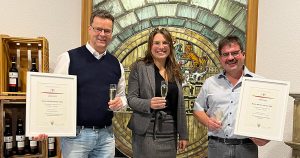 Tamara Elbl im Keller der Weinkellerei Hohenlohe, zusammen mit Geschäftsführer Eberhard Brand und Kellermeister Marc Schmitgall, sie übergibt die beiden Siegerurkunden zum "Besten Württemberger"