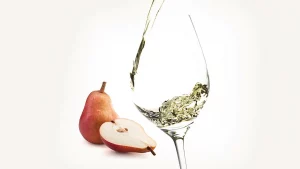 Grafik zur Rebsorte Kerner: Weinglas mit Weißwein, daneben eine angeschnittene Birne als typisches Aroma des Kerner.