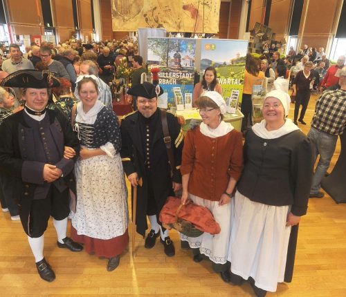 Wein-Lese-Tage in Marbach: Mehrere historisch bekleidete Marbacherinnen und Marbacher vor einem Marketing-Stand der Stadt