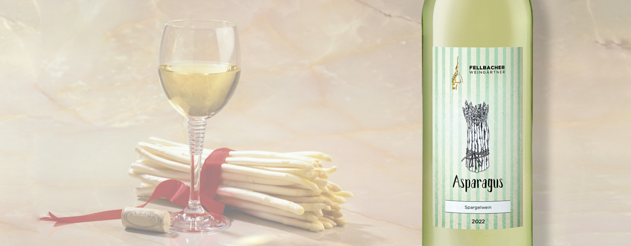 Weißweinglas mit Spargel, genau genommen rohen Spargelstangen mit schleife, daneben eine Flasche des Rivaners Asparagus trocken der Fellbacher Weingärtner