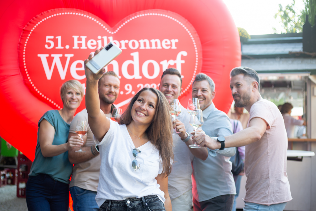 Junge Menschen auf dem Heilbronner Weindorf machen ein Selfie.