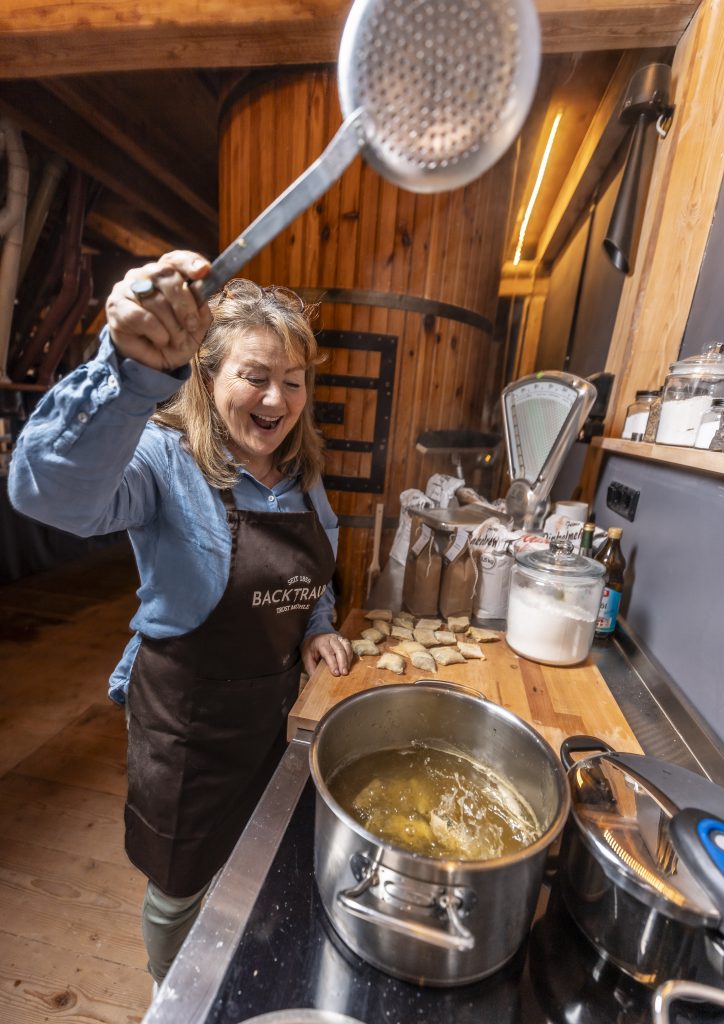 Andrea Trost hantiert begeistert in der Küche, vor ihr ein Topf mit Maultaschen im Sud.