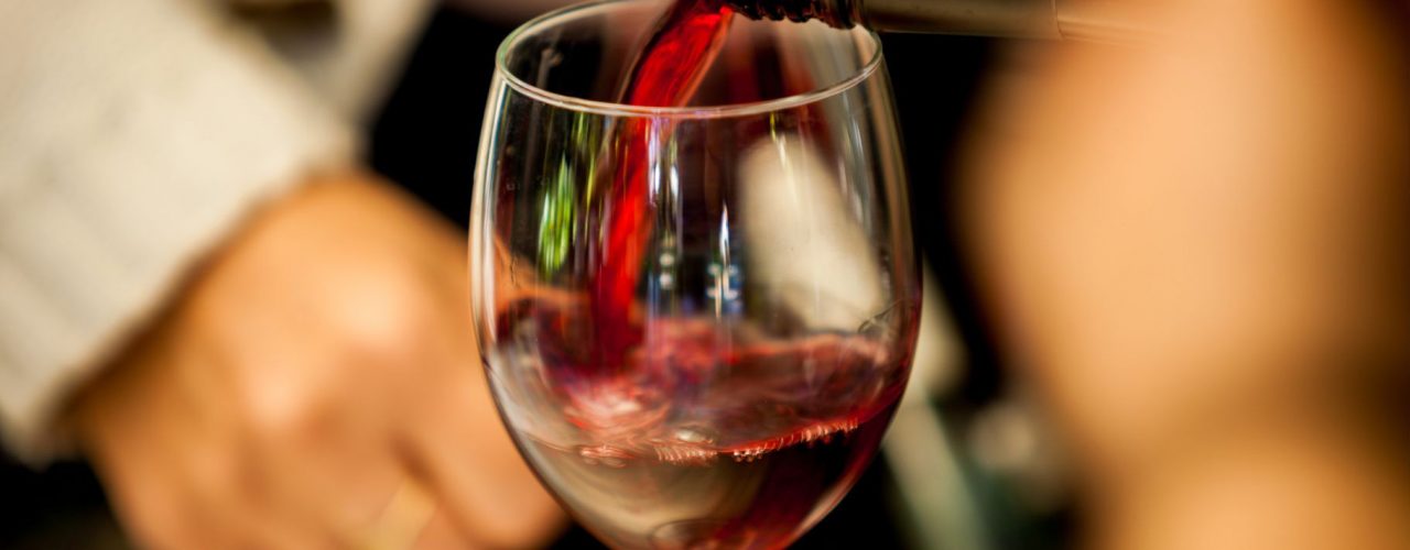 Titelbild zu Württembergs beste Weine für die Festtage, man sieht ein Glas, in das Rotwein eingeschenkt wird.