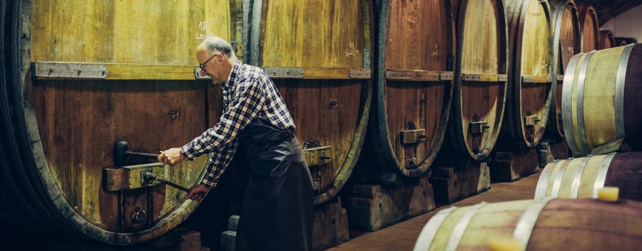 Jürgen Off, Kellermeister der Weinmanufaktur Stuttgart arbeitet an einem großen Holzfass im Keller der Weinmanufaktur.