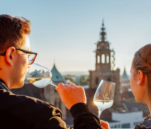 Ein Paar bei der Weinprobe mit Blick auf den Hafenmarktturm in Heilbronn